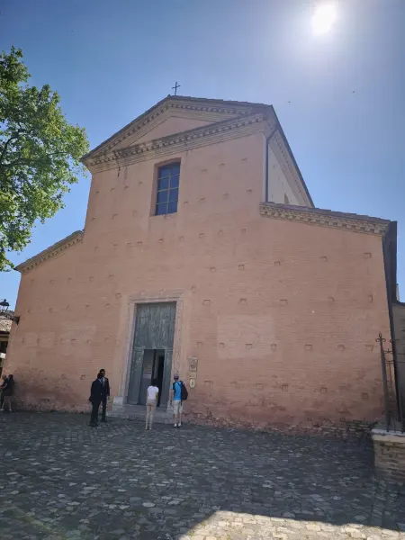 La facciata in laterizio della basilica illuminata di sera